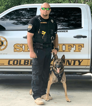Deputy Mike Booth and K-9 Hammer in front of a Colbert County Sheriff truck.