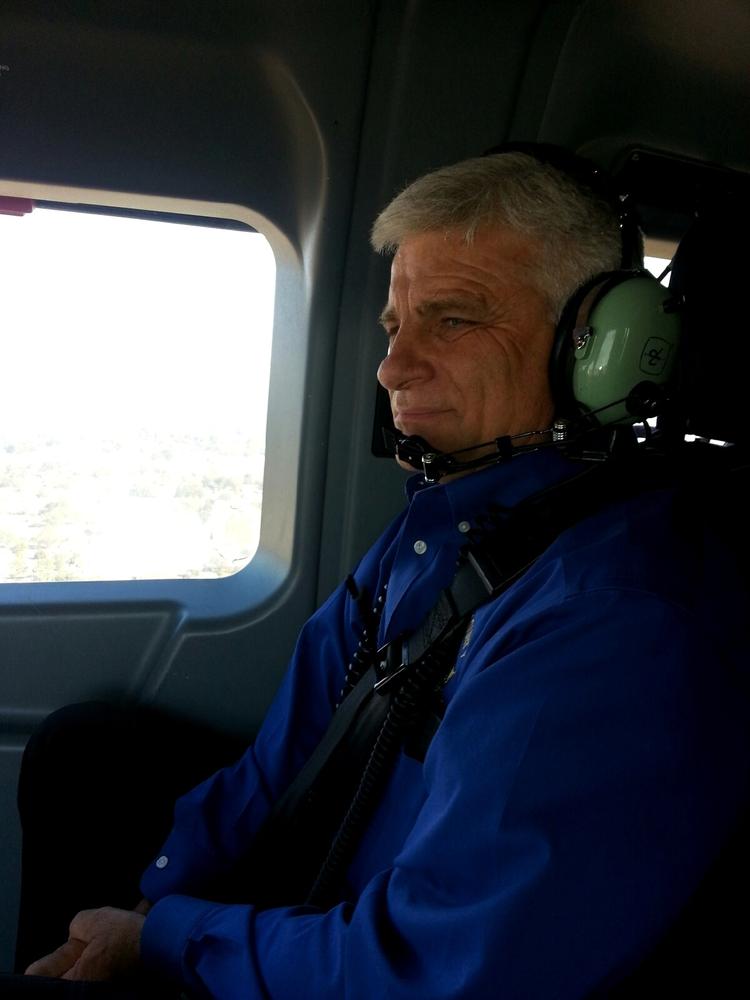 A man sitting in the helicopter with a headset on.