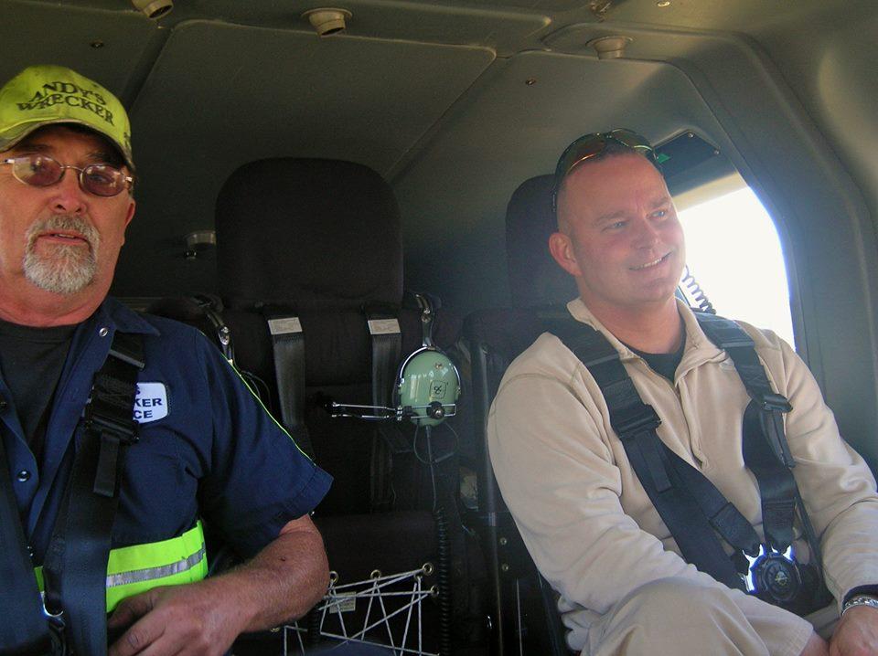 Two men sitting inside of the helicopter.