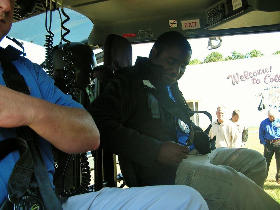 Two more men buckling themselves in the helicopter for their ride.